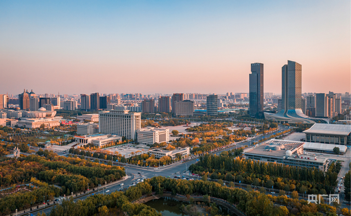 夕阳下的城市，高楼与秋意盎然的树林交相辉映（央广网记者  齐平  摄）