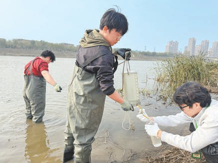 学生们相互配合收集水样。本报记者 陈强摄