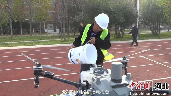 图为比赛选手赛前为植保无人机加水。 王晓慧 摄