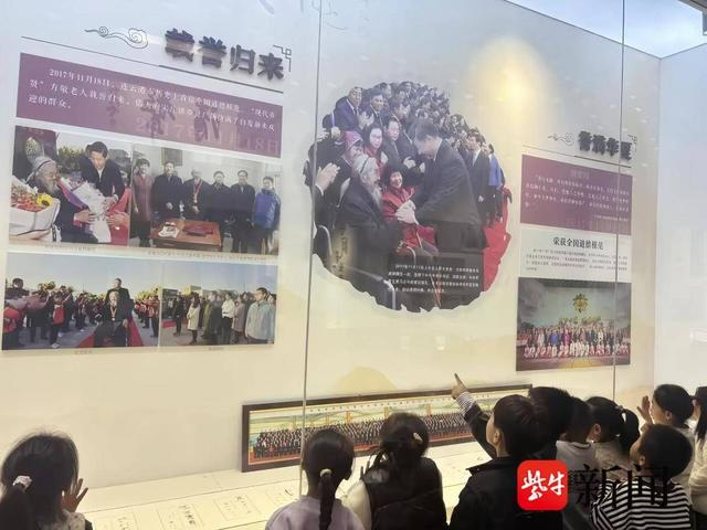 孩子们驻足观看楷模图文介绍 郭琳琳摄