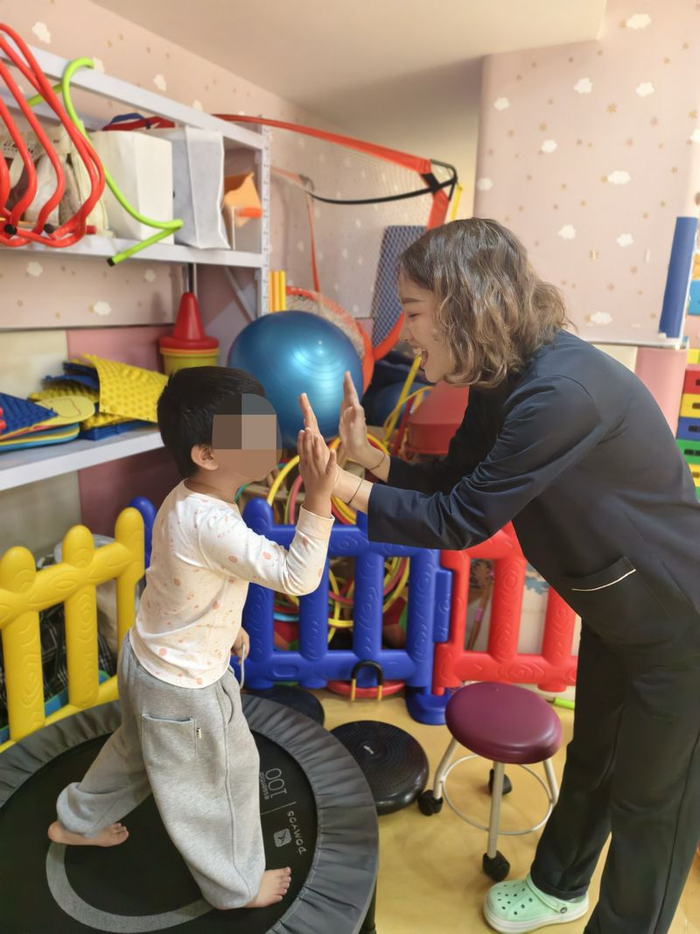 哞哞完成蹦床训练后，董凡凡击掌鼓励。新京报记者 刘思维 摄