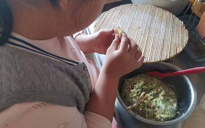 雯雯给王梅“打下手”包饺子。受访者供图