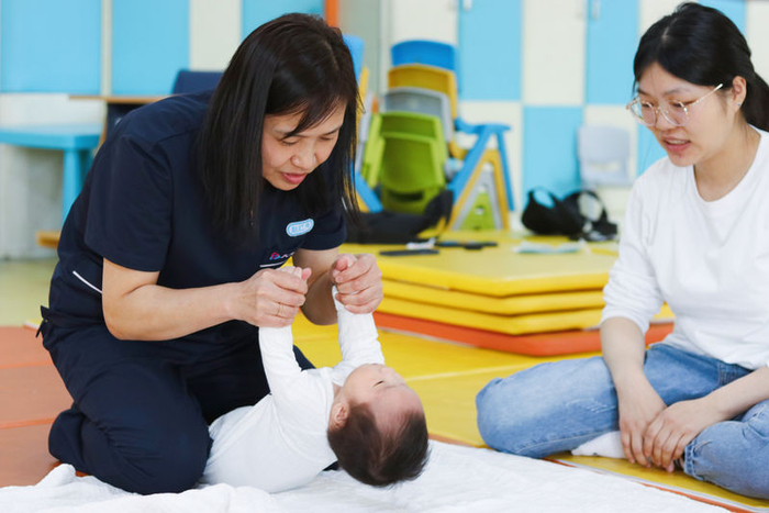 赵红伟给3个半月的宝宝做运动训练。受访者供图