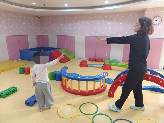 11月14日，大兴区妇幼保健院儿童康复园，董凡凡正在给康复儿童上“运动课”。新京报记者 刘思维 摄