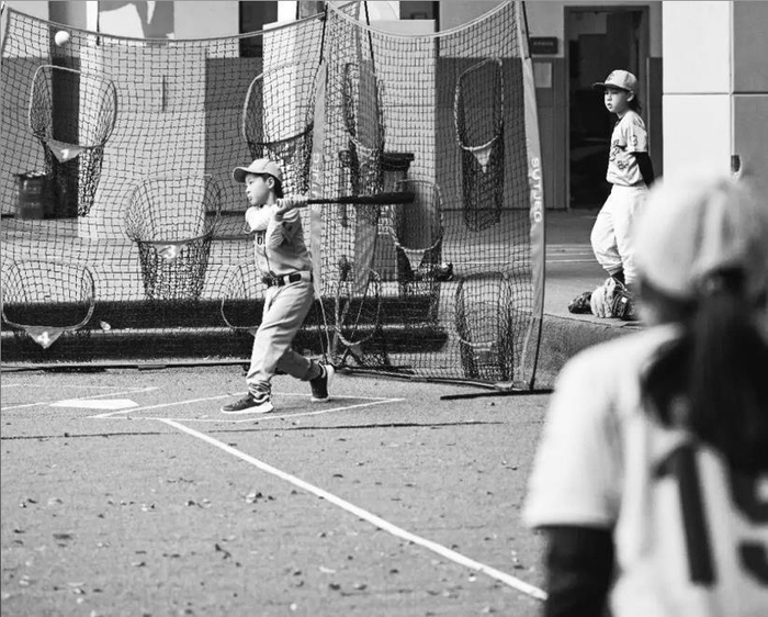         参加棒球社团的学生在练习棒球。