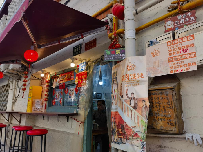 　　上海市徐汇区一家馄饨店门口张贴的电影海报和凭票根打折信息（2025年11月26日摄）。新华社记者陈爱平 摄