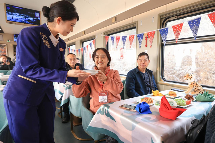 11月26日，工作人员在Y783次“悠享龙江·银旅号”旅游列车上为旅客准备特色餐食。图源新华社