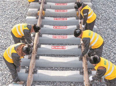 图为11月25日，工人在黑龙江省绥化市庆安县永华村哈伊高铁哈铁段铺轨现场工作。 新华社记者 王松  摄