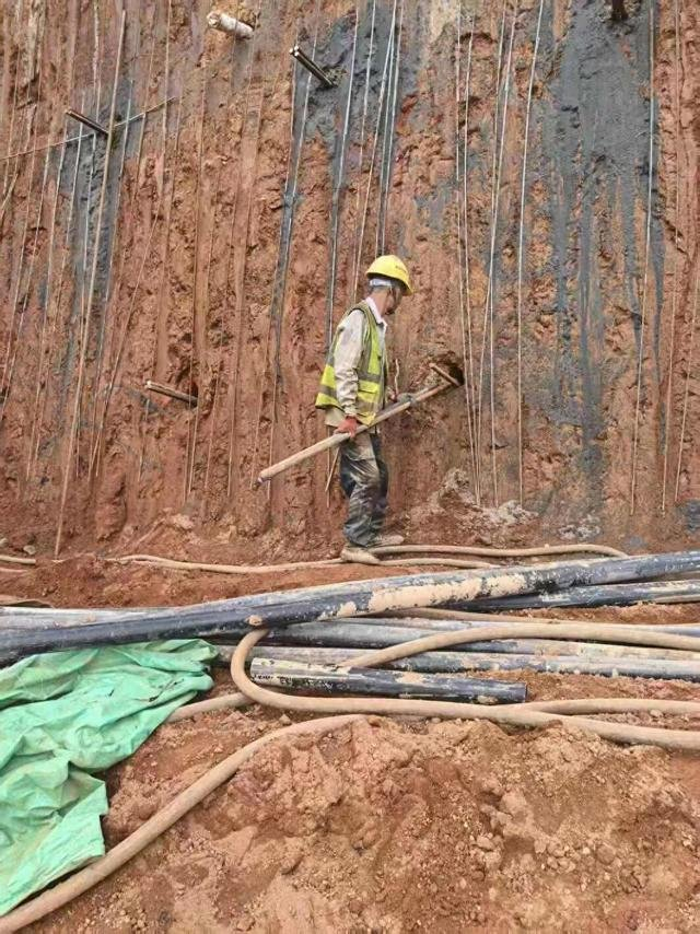 工人在徒手将两根钢筋插入孔洞，钢筋长度约两米。 资料照片