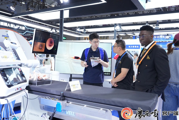 参展商向记者介绍其带来的肺部诊疗一体化手术机器人。广西云-广西日报记者 古秀芳 摄