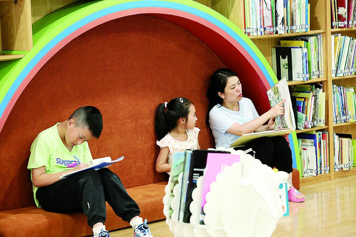     巴南区图书馆内，市民带着孩子在学习充电。
