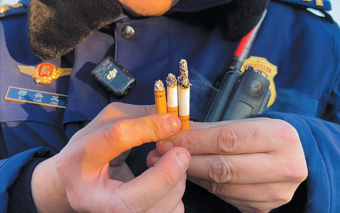 消防员从36米高空依次扔下的3支点燃的香烟，落地后依旧着着。 新京报记者 张静姝 摄