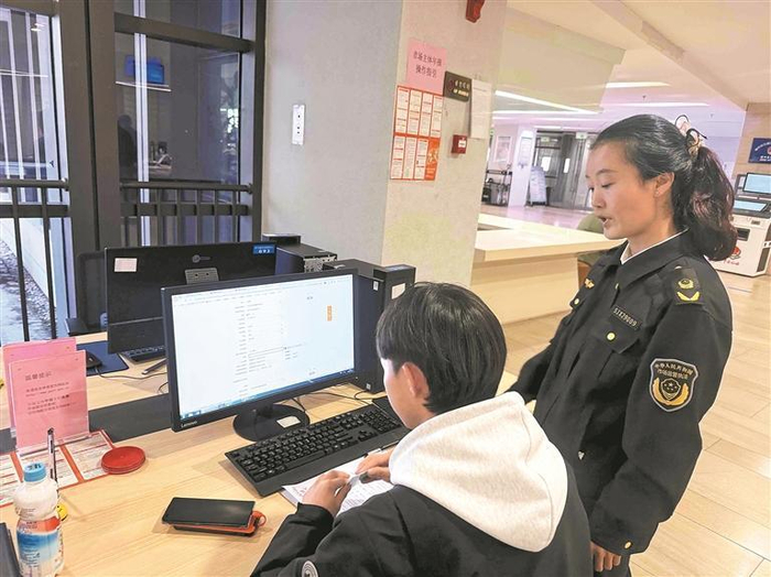 工作人员正协助申请者办理业务。本报记者 董洁 摄