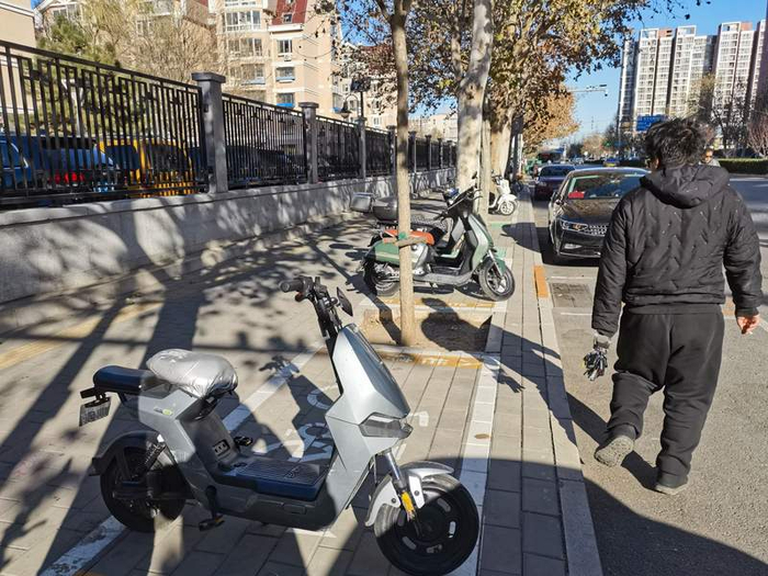 在姚家园一个居民小区外，一名二手车卖家带领购买者挑选车辆。新京报记者 王贵彬 摄