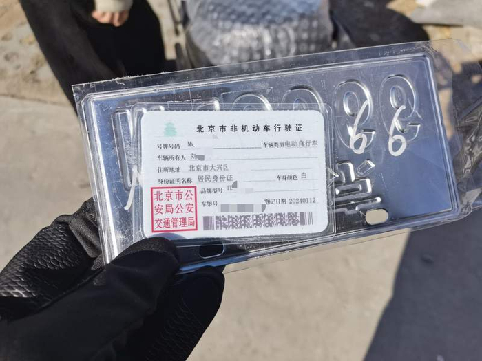商家提供的一辆电动自行车的行驶证显示车身为白色，而车辆实际是黑色，明显不一致。新京报记者 王贵彬 摄