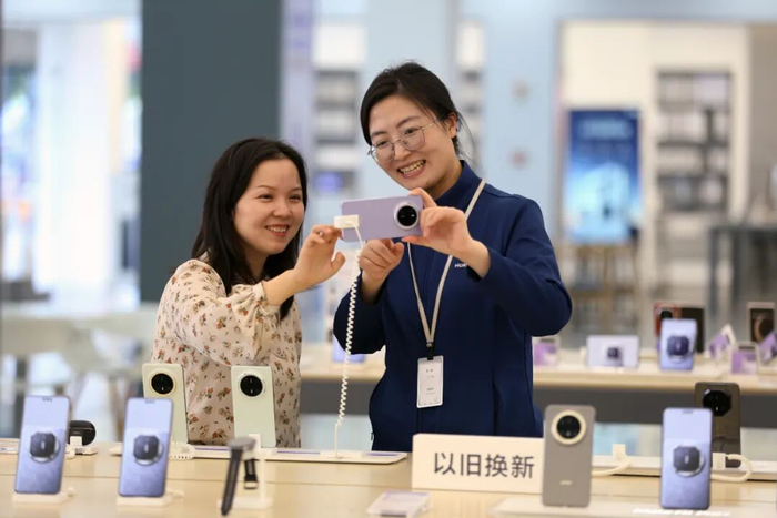 四川省乐山市市民在商场内选购手机。李华时摄