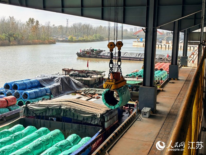 机械臂抓起钢帘线盘条，通过专用传输带直运到生产车间。人民网 崔小倩摄