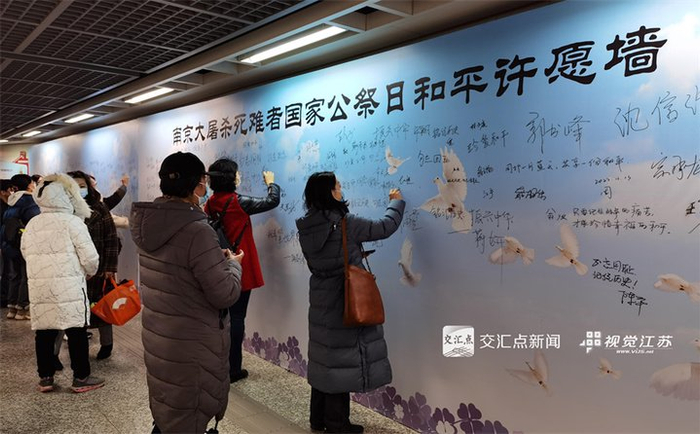 2022年12月12日，市民在“南京大屠杀死难者国家公祭日和平许愿墙”上写下各自心声。新华日报·交汇点记者 宋宁 摄