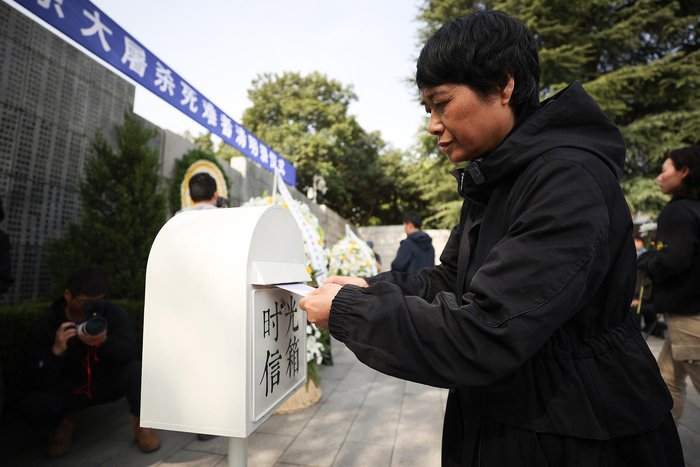 ▲4月4日，常小梅将写给父亲的一封信投入“时光信箱” 中新社记者 泱波 摄 据视觉中国