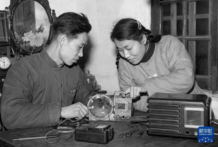 1960年，上海市徐汇区现代无线电行一名职工（左）为居民检修收音机，并向她讲解保养知识。新华社记者 霍生联 摄