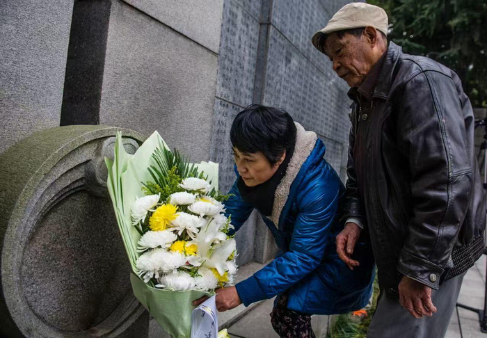 ▲常志强和女儿常小梅在家祭中向当年遇难的亲人献花 新华社发