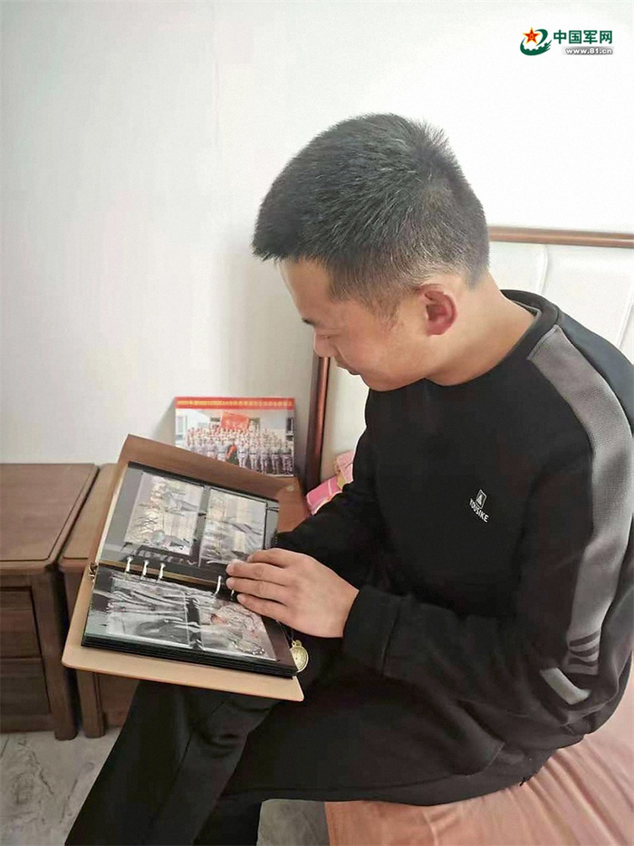 　　一名老兵在家中翻看纪念册。