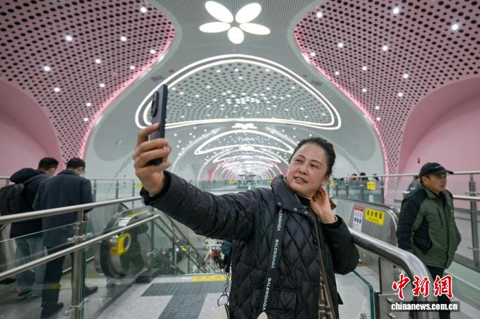 一名乘客在幸福梅林站厅用手机自拍。记者 刘忠俊 摄