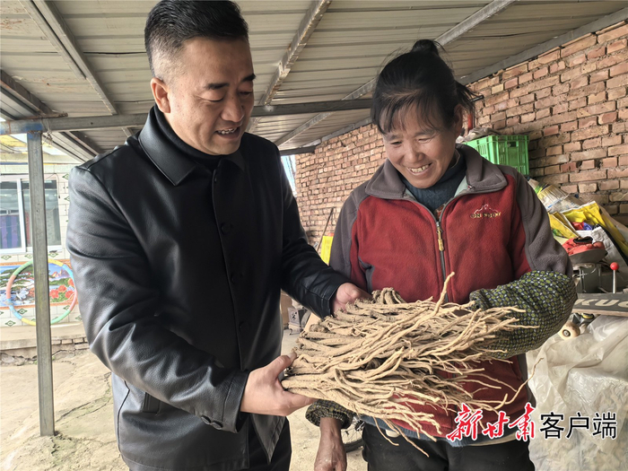 驻村第一书记王涛了解陈金娥（右）家的中药材情况。