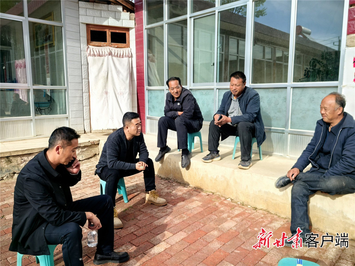 王涛（左二）与村民唠家常。元古堆村村委会提供