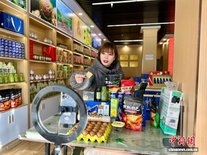 2025年12月，甘肃陇南市武都区，电商从业人员直播介绍当地的新品网货核桃锅巴。中新社记者 闫姣 摄
