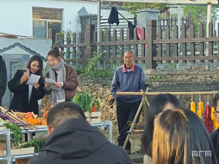 村民看年轻人竞拍（央广网记者  王锡斐  摄）