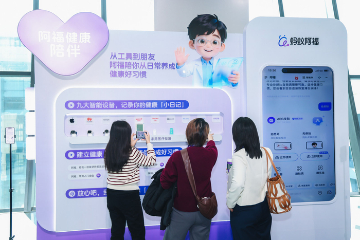 图为居民在了解“蚂蚁阿福”App的功能介绍。资料照片