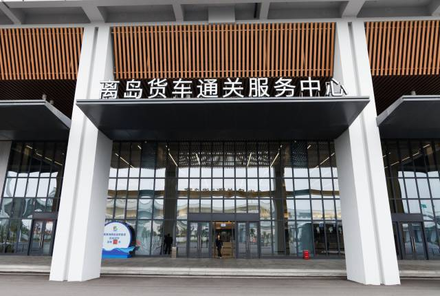 位于新海港和南港“二线口岸”（货运）集中查验场的离岛货车通关服务中心入口处。图源新华社