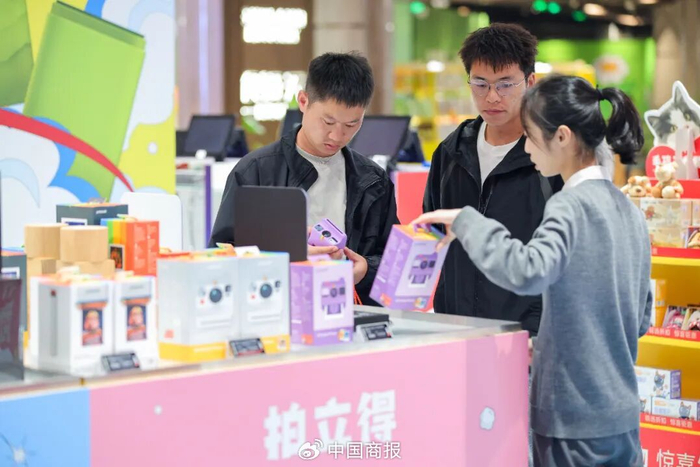 △图为消费者在cdf海口国际免税城选购拍立得相机。（图片由CNSPHOTO提供）