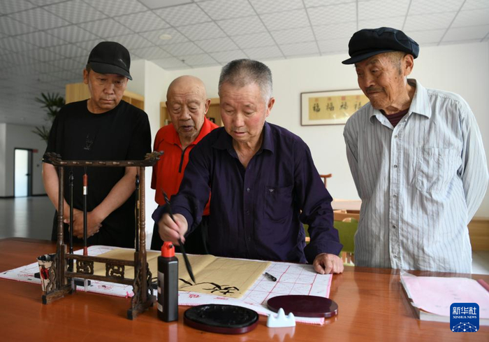 老人们在养老服务中心进行书法活动。图源：新华社