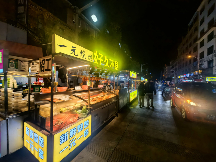 体育场附近的一个十字路口因为中超联赛的举办，诞生了一个夜市。（雷鸣 摄）