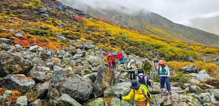 图为游客在西藏日喀则珠峰东坡徒步旅行 