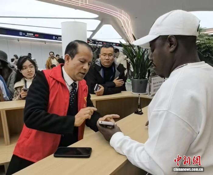    来自尼泊尔的王子为外国人讲解办事流程。 左雨晴 摄