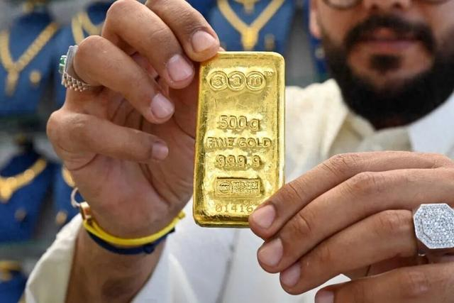 10月23日，在科威特首都科威特城，一名男子在金店内展示500克的金条。新华社发（阿萨德 摄）