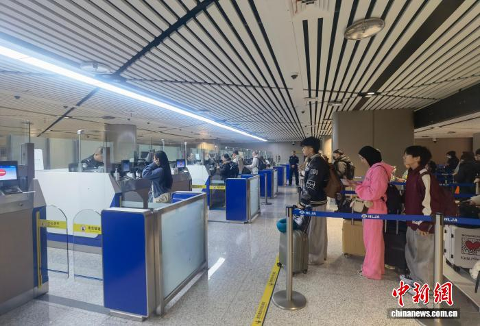 出入境旅客在哈尔滨太平国际机场口岸办理通关手续。　王冀明 摄