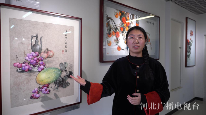 滕氏布糊画传承人王思雨向记者介绍布糊画作品《清风紫玉醉楼兰》