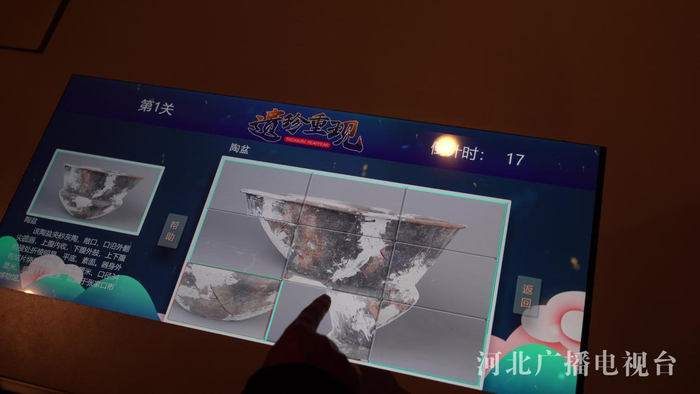 在博物馆多媒体互动体验区，游客正在通过闯关游戏了解文物知识