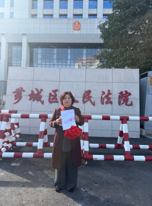 ▲芗城区法院门口，林惠荣手持无罪判决书。图/王殿学