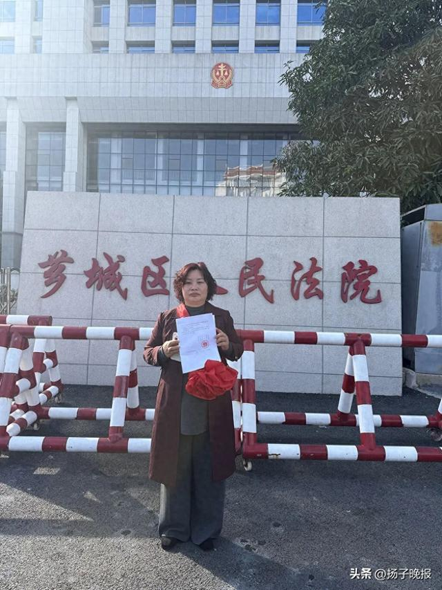 ▲芗城区法院门口，林惠荣手持无罪判决书。图片来源：王殿学