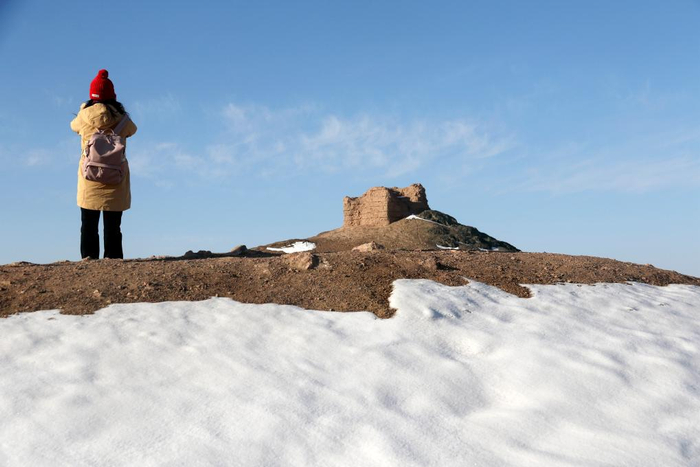 　　游客在雪后的甘肃省敦煌市阳关景区拍照游览。新华社发（张晓亮 摄）