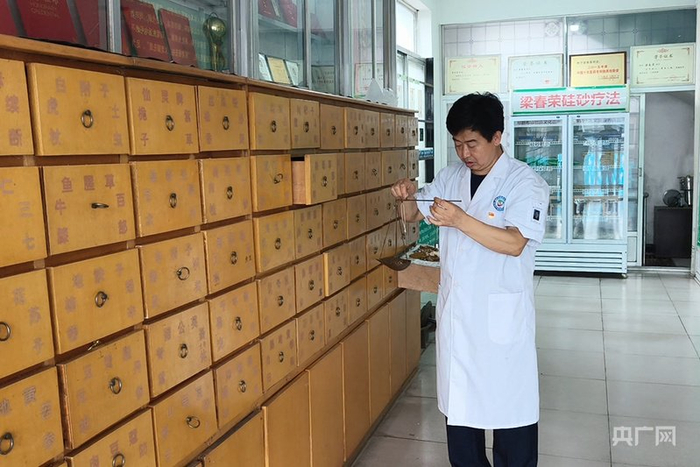 梁春荣在卫生室为患者称药（央广网记者  白德彰  摄）