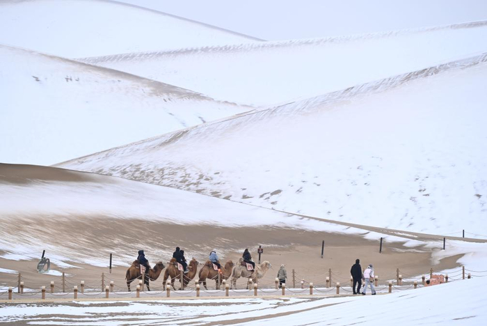 　　游客在甘肃省敦煌市鸣沙山月牙泉景区游览。新华社发（张晓亮 摄）