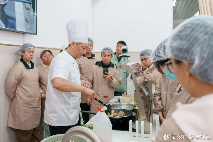 同学们围看大厨煸炒排骨