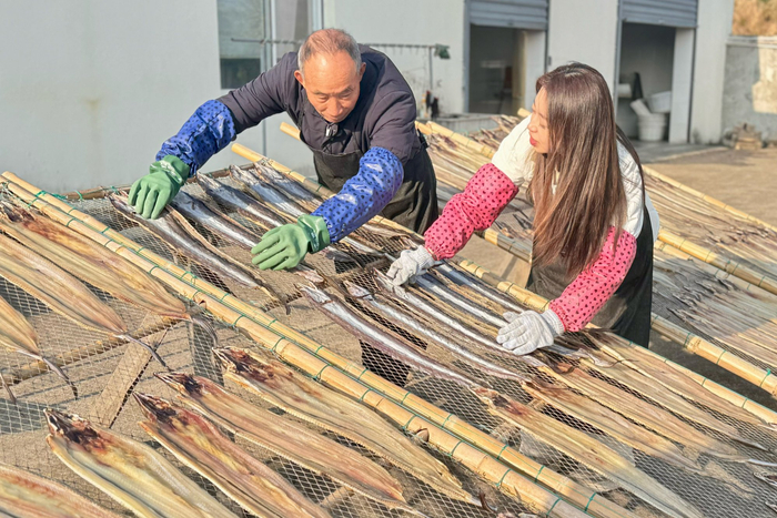 记者体验晒鱼鲞（央广网记者 陈金莲 摄）