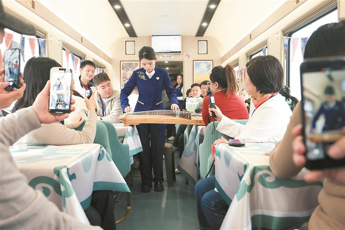 图为工作人员在“悠享龙江·银旅号”旅游列车上为旅客表演古筝。